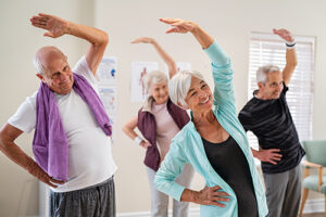 Group of seniors doing stretching exercise together at retirement community.